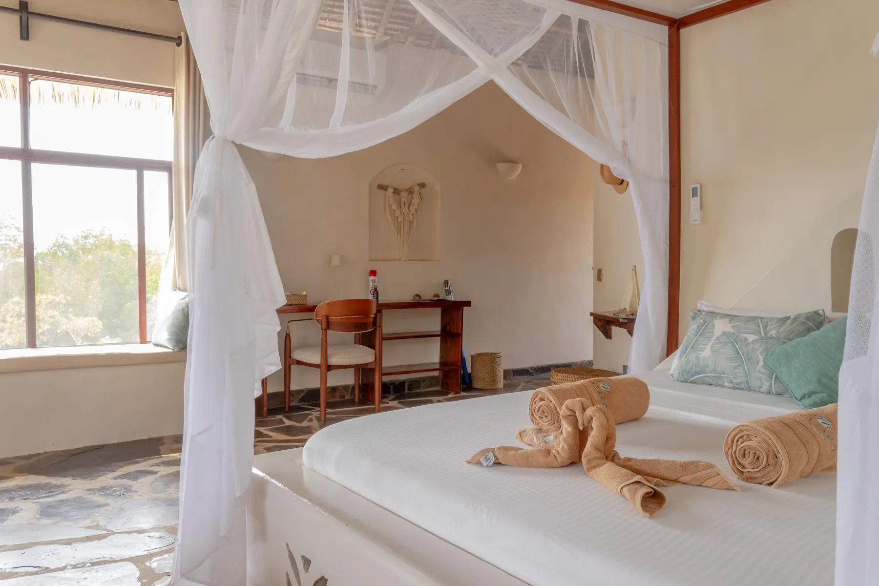 Four-poster bed with white canopy and garden view
