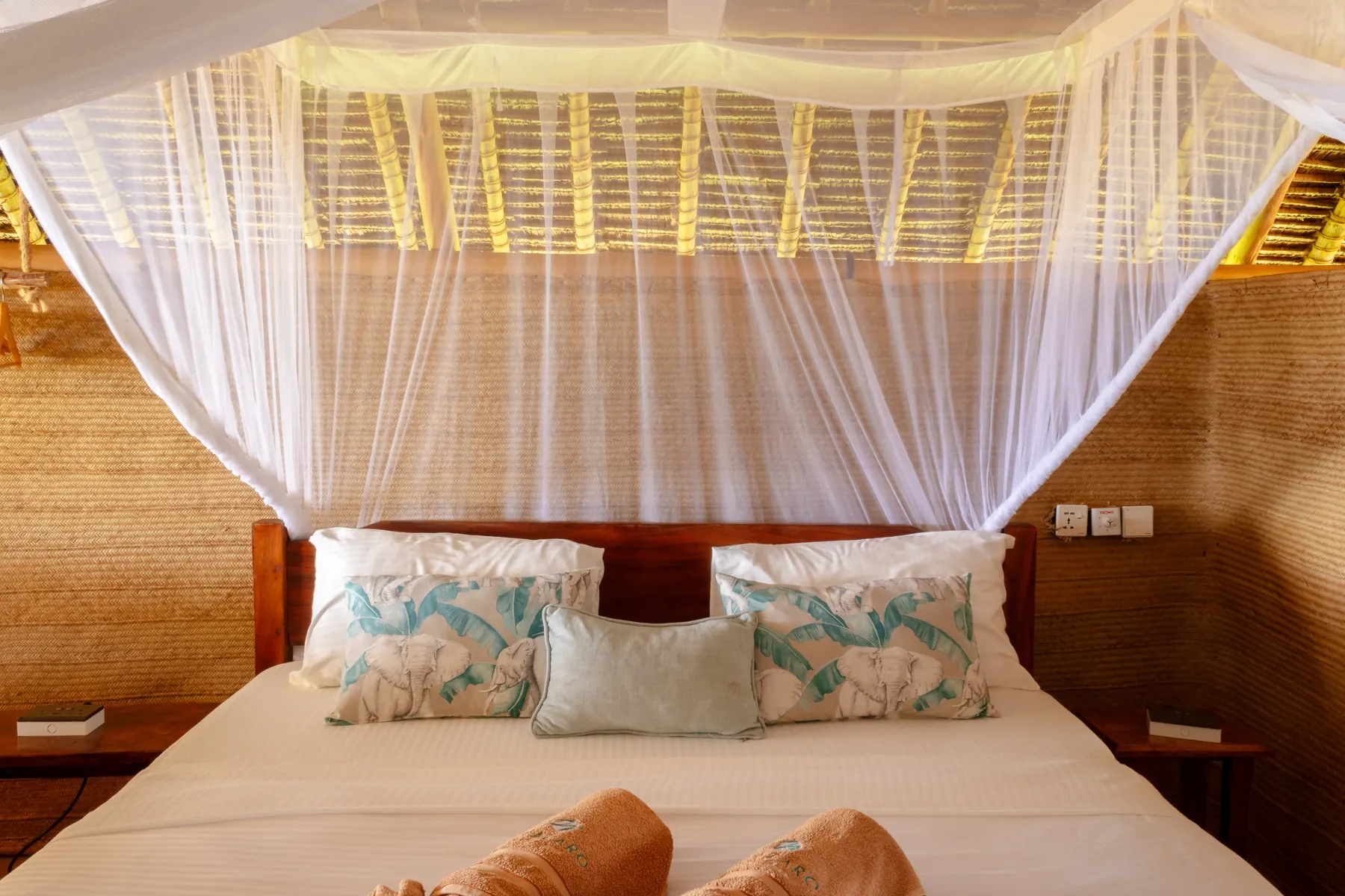 Canopy bed framed by warm earthen walls