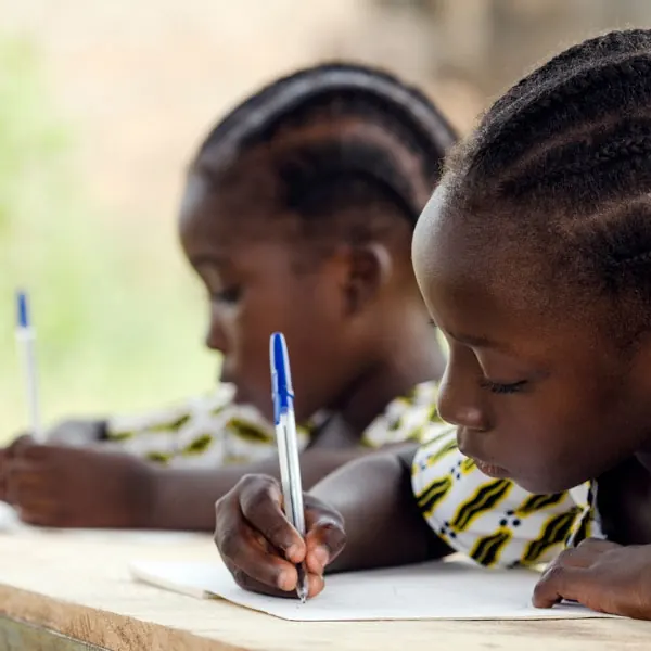 Children writing in class at the Kidimu School